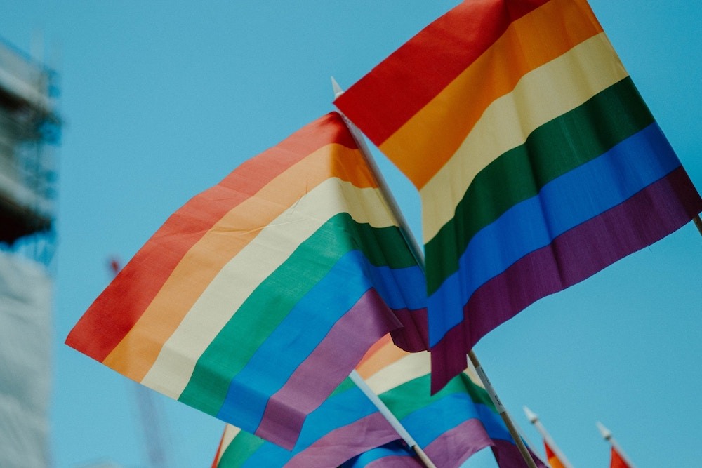 Image of fluttering rainbow pride flags.
